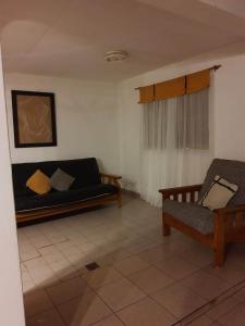 ein Wohnzimmer mit einem Sofa und einem Stuhl in der Unterkunft Mirhouse1 in Puerto Madryn