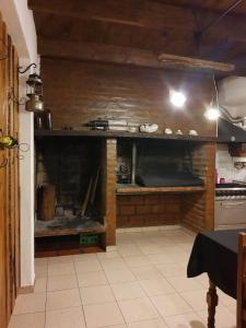 a kitchen with a brick wall with a fireplace at Mirhouse1 in Puerto Madryn