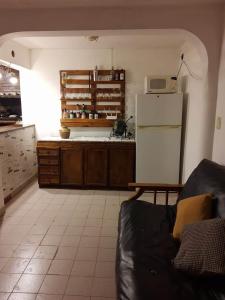 eine Küche mit einem Sofa und einem weißen Kühlschrank in der Unterkunft Mirhouse1 in Puerto Madryn