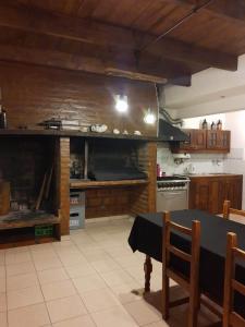 a large kitchen with a table and a fireplace at Mirhouse1 in Puerto Madryn