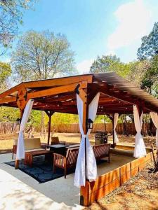 un pabellón de madera con mesa y bancos en un parque en Manchaca Meadows - 4 Bedroom Villa, en Manchaca