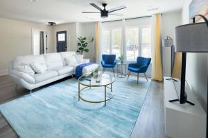 a living room with a white couch and blue chairs at Manchaca Meadows - 4 Bedroom Villa in Manchaca