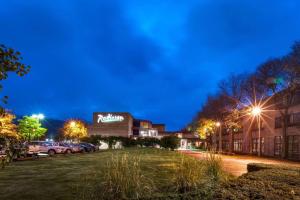 ein Gebäude mit nachts auf einem Parkplatz geparkt in der Unterkunft Radisson Hotel Corning in Corning