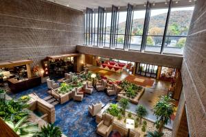 einen Blick über eine Lobby mit Sofas und Pflanzen in der Unterkunft Radisson Hotel Corning in Corning
