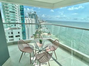 卡塔赫納的住宿－U-GO Edificio Murano Elite Bocagrande Frente al Mar，一个带桌椅的海景阳台
