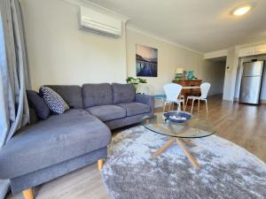 a living room with a couch and a table at Fairways Golf & Beach Retreat Bribie Island in Woorim