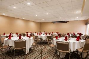 uma sala com mesas e cadeiras com guardanapos vermelhos em Radisson Akron-Fairlawn Copley em Fairlawn