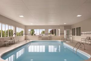 una grande piscina con sedie e tavolo di Country Inn & Suites by Radisson, Port Clinton, OH a Port Clinton
