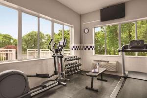 a fitness room with a gym with a treadmill and windows at Country Inn & Suites by Radisson, Port Clinton, OH in Port Clinton