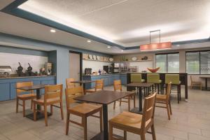 a restaurant with tables and chairs and a kitchen at Country Inn & Suites by Radisson, Port Clinton, OH in Port Clinton