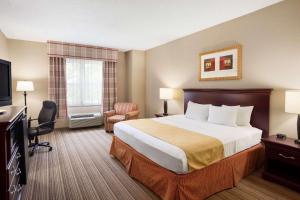 a hotel room with a bed and a television at Country Inn & Suites by Radisson, Ithaca, NY in Ithaca