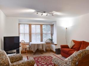 a living room with a couch and a table at Sycamore Cottage - Uk45923 in Ballater