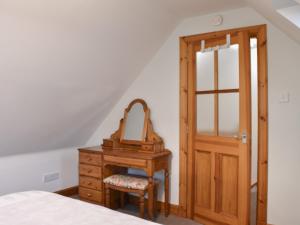 a bedroom with a dressing table and a mirror at Sycamore Cottage - Uk45923 in Ballater