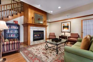 a living room with a fireplace and a couch at Country Inn & Suites by Radisson, Marion, OH in Marion