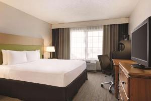 スプリングフィールドにあるCountry Inn & Suites by Radisson, Springfield, OHのベッドとテレビが備わるホテルルームです。