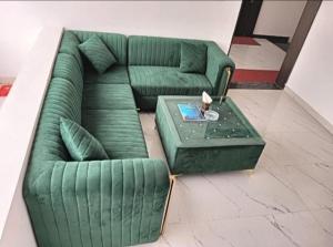 a green couch and a table in a room at Hostel Arabian Night in Khajurāho