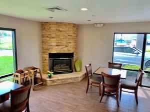 a living room with a fireplace and tables and chairs at Country Inn & Suites by Radisson, Sandusky South, OH in Milan