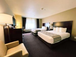 a hotel room with two beds and a couch at Country Inn & Suites by Radisson, Bend, OR in Bend