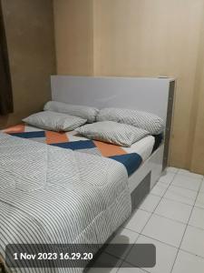 two twin beds in a room with at Kalibata city apartemen tower akasia in Jakarta