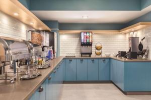 cocina con armarios azules y encimera en Country Inn & Suites by Radisson, Erie, PA, en Erie