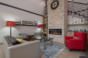 sala de estar con sofá y chimenea en Country Inn & Suites by Radisson, Harrisburg Northeast - Hershey, en Harrisburg