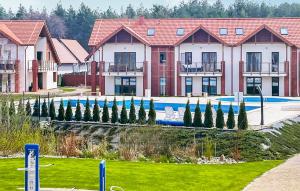 a building with a pool and a row of trees at Awesome Apartment In Zarnowska With Heated Swimming Pool in Żarnowska