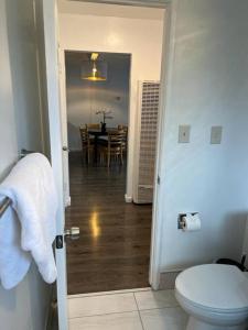 a bathroom with a toilet and a dining room with a table at New 2BR 1Bath w/ Free Parking & Laundry near University of Berkeley in Richmond