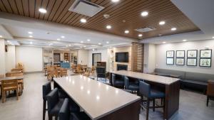 a dining room with tables and chairs and tablesktop at Country Inn & Suites by Radisson, State College Penn State Area , PA in State College