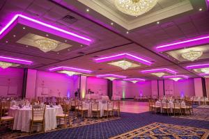 un salón de banquetes con mesas, sillas e iluminación púrpura en Radisson Hotel Philadelphia Northeast en Trevose