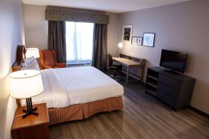 a hotel room with a bed and a desk and a television at Country Inn & Suites by Radisson, Harrisburg West Mechanicsburg in Mechanicsburg