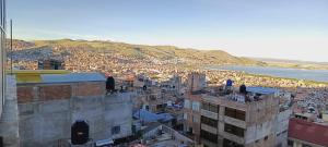 a view of a city with buildings and the ocean at Departamento 3 niveles- Vista Panoramica 360 grados a toda la ciudad y Lago Titicaca in Puno