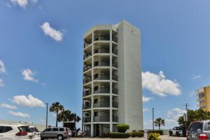a tall apartment building with cars parked in a parking lot at Ocean Trillium 601 A 1 Bedroom-1 Bath Ocean View Unit in New Smyrna Beach