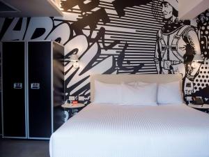 1 dormitorio con 1 cama y pared en blanco y negro en Radisson RED Miraflores en Lima