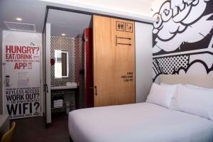 1 dormitorio con cama blanca y puerta de madera en Radisson RED Miraflores en Lima