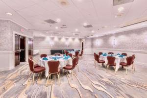 uma sala de conferências com mesas e cadeiras e um pódio em Radisson Hotel Providence Airport em Warwick
