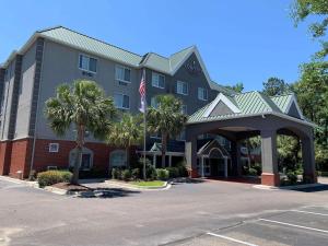 um hotel com uma bandeira americana num parque de estacionamento em Country Inn & Suites By Radisson, Charleston North, SC em Charleston