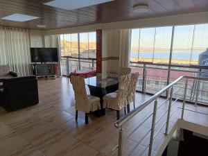 a living room with a table and chairs and a balcony at Departamento 3 niveles- Vista Panoramica 360 grados a toda la ciudad y Lago Titicaca in Puno