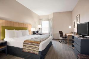 佛羅倫薩的住宿－佛羅倫薩江山旅館，酒店客房配有一张床、一张书桌和一台电视。