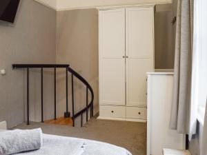een slaapkamer met een bed en een witte kast bij Victoria Apartment in Southport