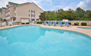 een groot zwembad met stoelen en een gebouw bij Country Inn & Suites by Radisson, Aiken, SC in Aiken