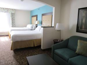 a hotel room with two beds and a couch at Country Inn & Suites by Radisson, Murrells Inlet, SC in Myrtle Beach