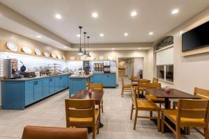 a restaurant with blue cabinets and wooden tables and chairs at Country Inn & Suites by Radisson, Anderson, SC in Anderson