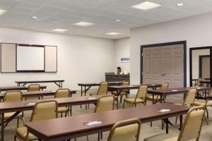 a classroom with tables and chairs and a screen at Country Inn & Suites by Radisson, Summerville, SC in Summerville