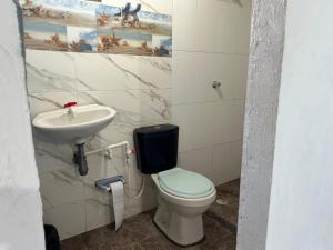 a bathroom with a toilet and a sink at Punta Arena EcoHostal & EcoFit 03 in Playa Punta Arena