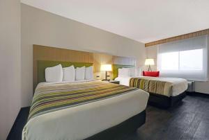 Habitación de hotel con 2 camas y ventana en Country Inn & Suites by Radisson, Pierre, SD, en Pierre
