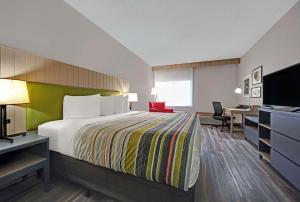 ピアにあるCountry Inn & Suites by Radisson, Pierre, SDのベッドとデスクが備わるホテルルームです。