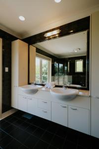 ein Badezimmer mit zwei Waschbecken und einem großen Spiegel in der Unterkunft Experience luxury at its finest in Whitford in Whitford