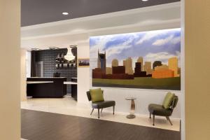 a lobby with two chairs and a painting of a city at Country Inn & Suites by Radisson, Nashville Airport, TN in Nashville