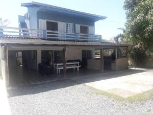 een huis met een veranda met een tafel en een balkon bij Sobrado com piscina e campinho! in Boa Vista