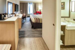 a hotel room with a bed and a bathroom at Country Inn & Suites by Radisson, Nashville Airport, TN in Nashville